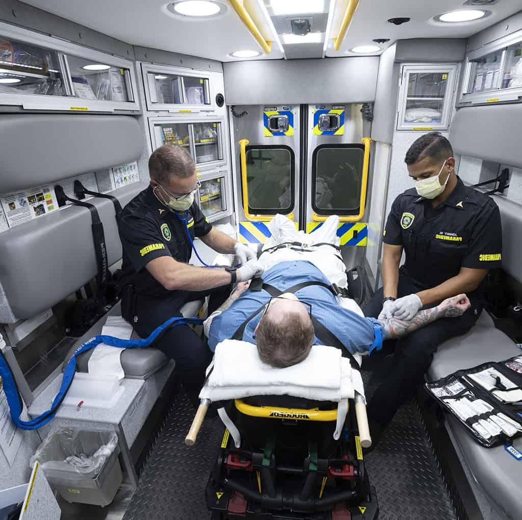 Two paramedics care for patient in ambulance